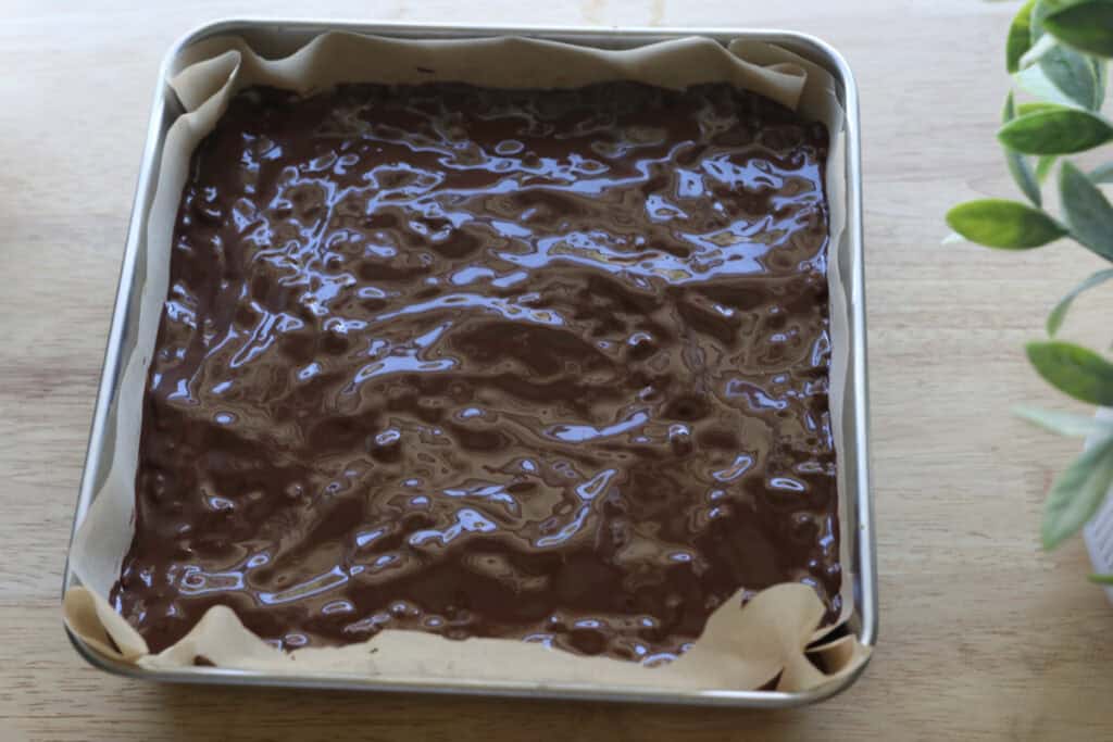 Chocolate Peanut Butter Rice Krispie Bars in a metal 8x8 pan with parchment paper