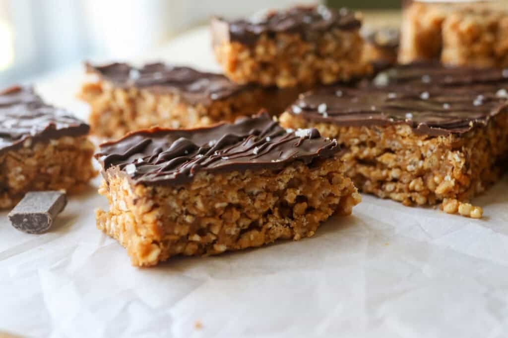 a Peanut Butter Rice Krispie Bar with chocolate on top and more bars behind it