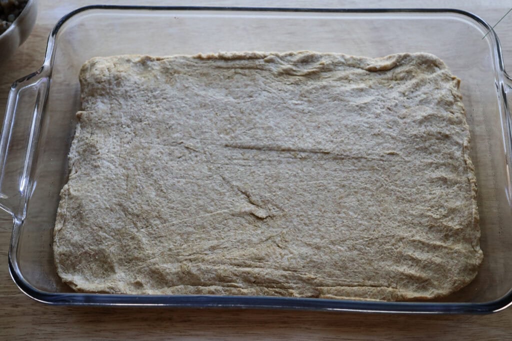 biscuit dough pressed into the bottom of the pan for the freshly milled breakfast casserole 