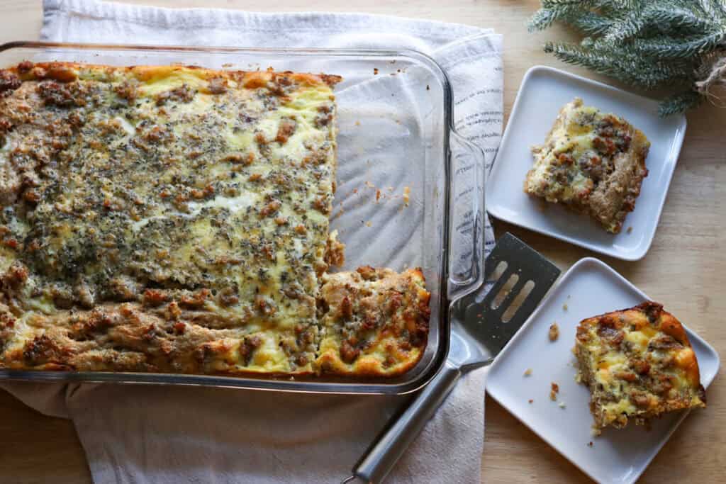 freshly milled breakfast casserole in a glass dish with 2 pieces on white plates