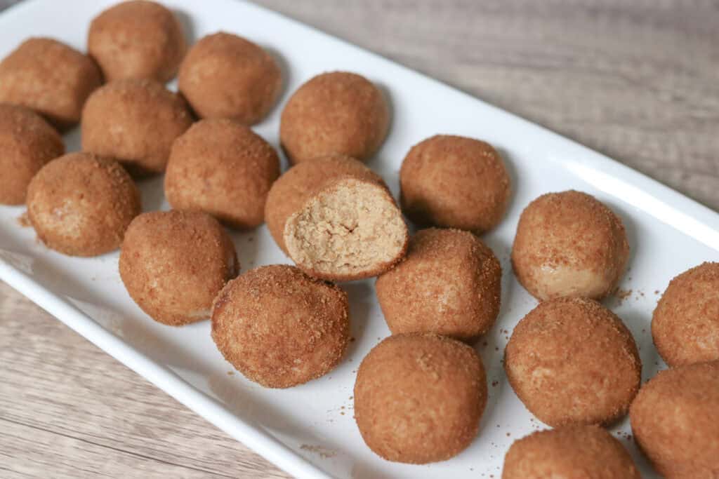 a bunch of healthy snickerdoodle protein balls arranged on a white tray