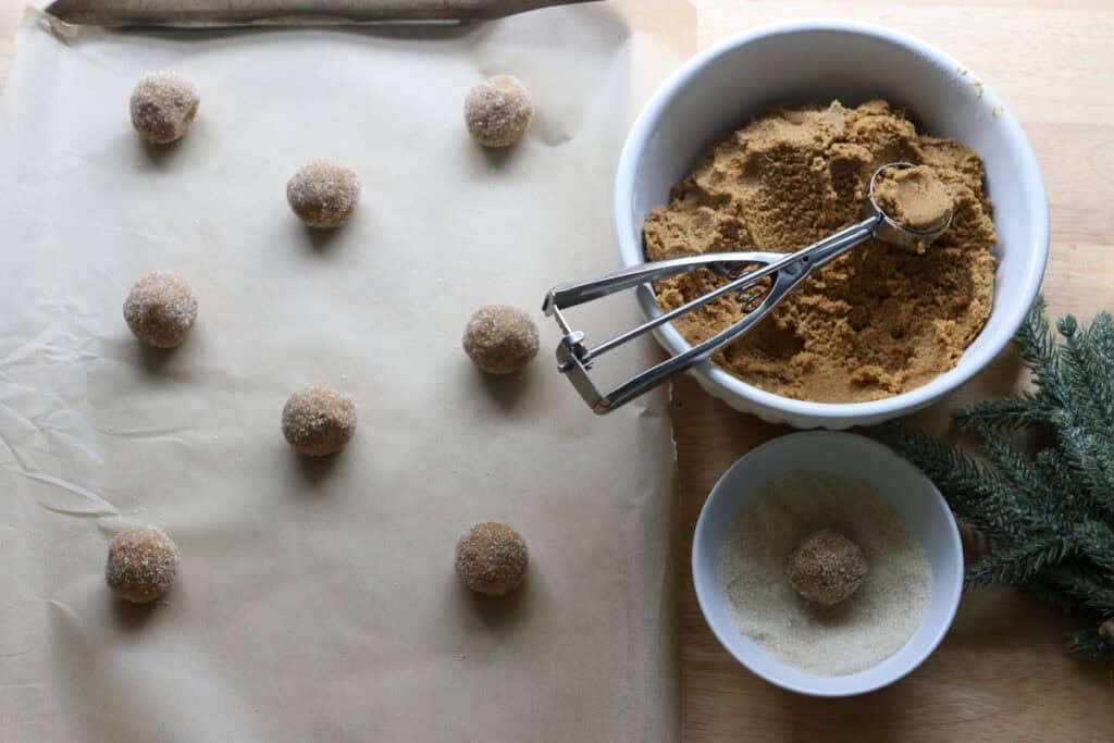scooping out fresh milled gingersnap cookie dough onto a baking sheet