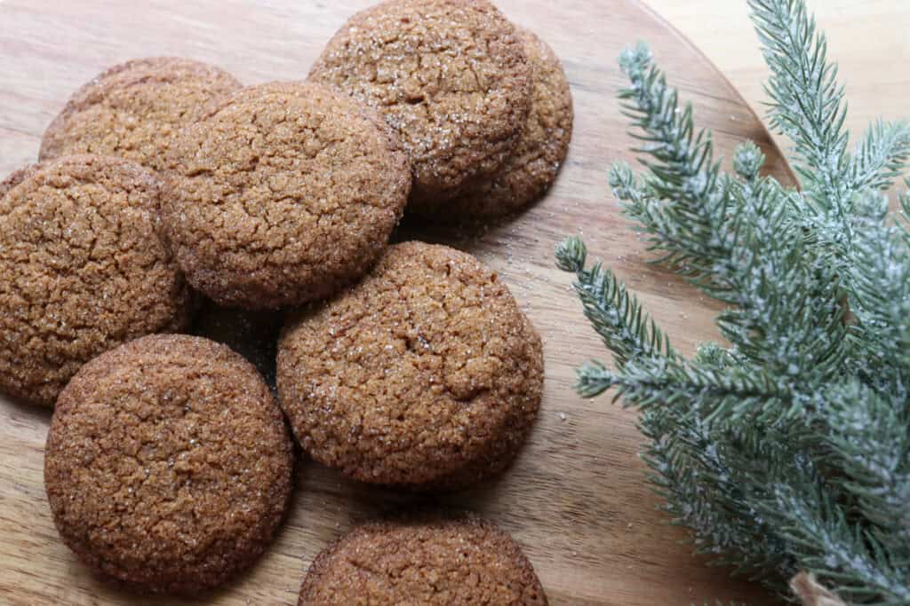 fresh milled gingersnap cookies on a wooden board with greenery