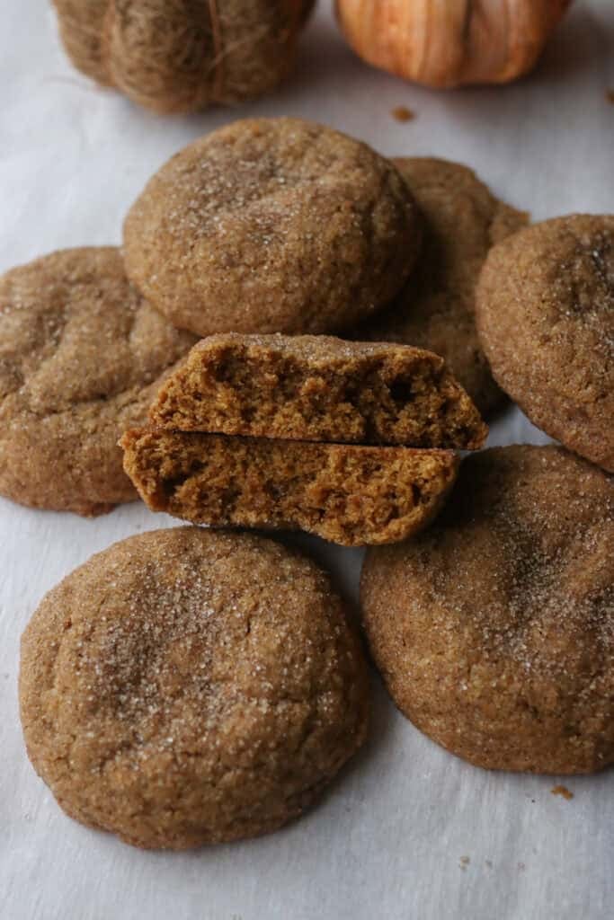 a Freshly Milled Brown Butter Maple Pumpkin Cookie cut in half with other behind it 