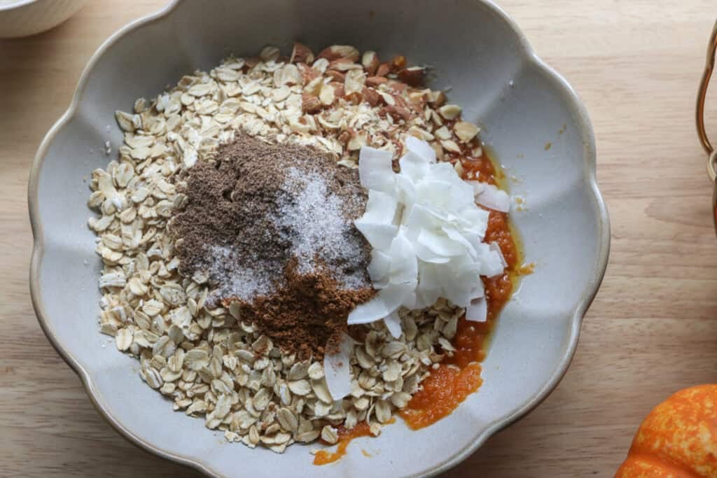 oats, flax, coconut, and pumpkin in a bowl to make The Best Crunchy Maple Pumpkin Spice Granola