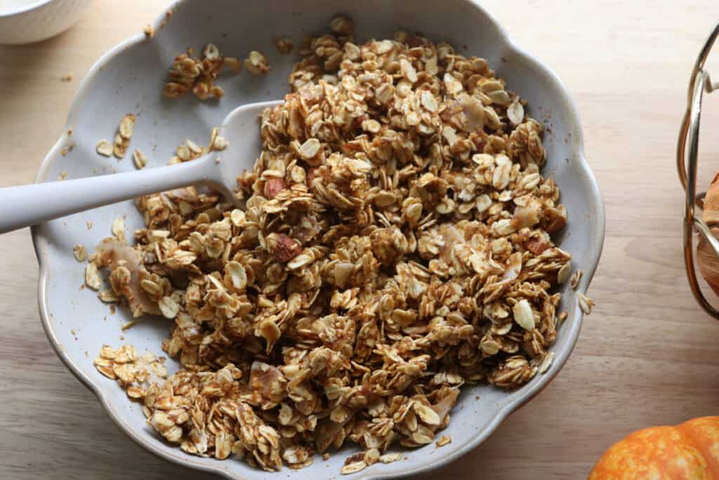 Crunchy Maple Pumpkin Spice Granola that has been stirred together in a bowl 