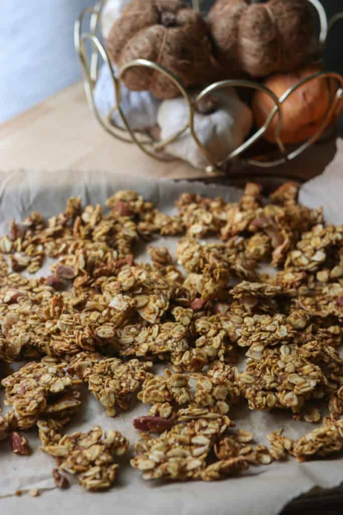 Crunchy Maple Pumpkin Spice Granola on a sheet pan with parchment paper