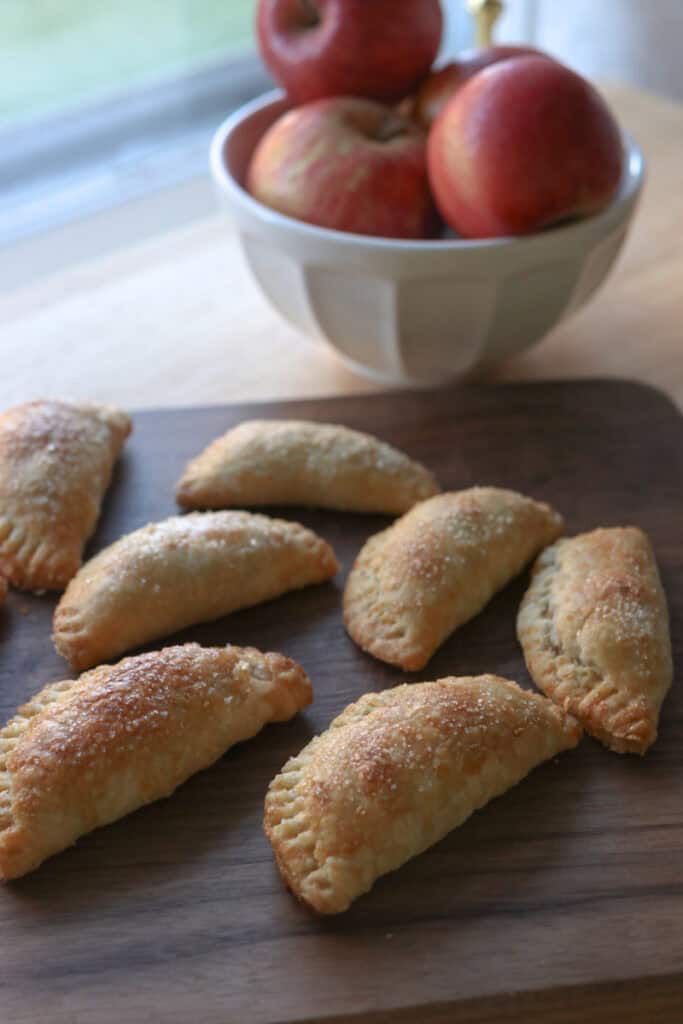 freshly milled healthy apple hand pies on a wooden cutting board