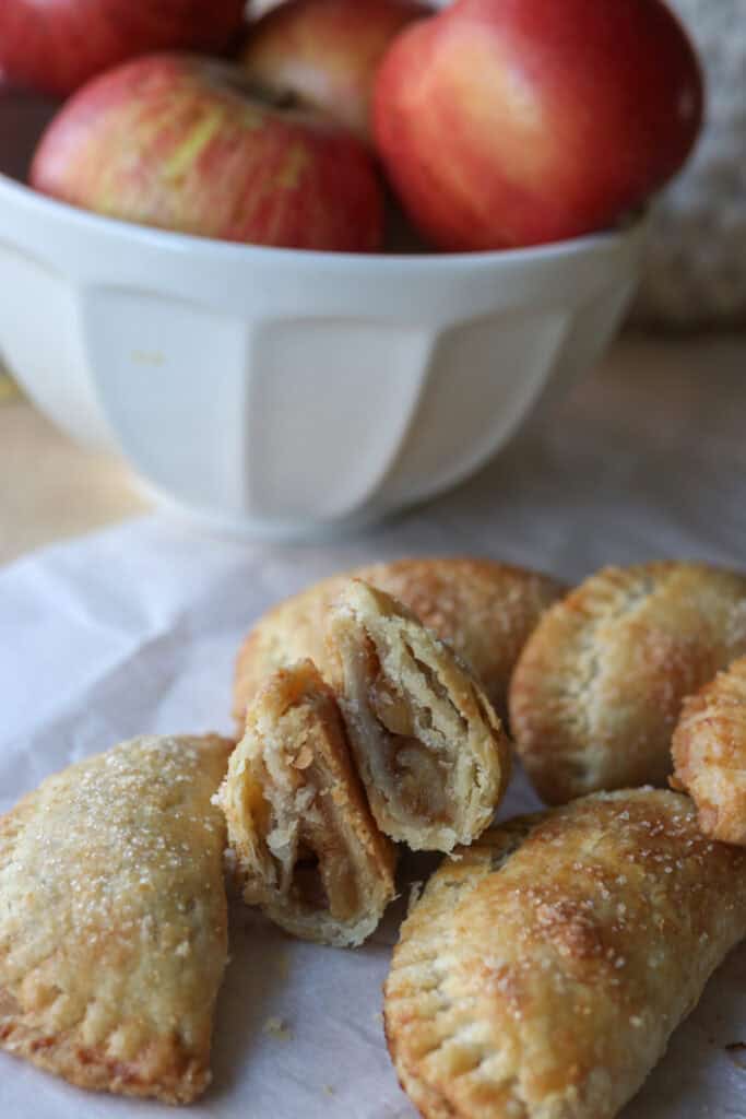freshly milled healthy apple hand pies with one cut in half on parchment