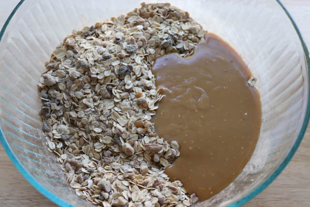oats and cashew butter in a glass bowl to make Healthy and Crunchy Protein-Packed Granola