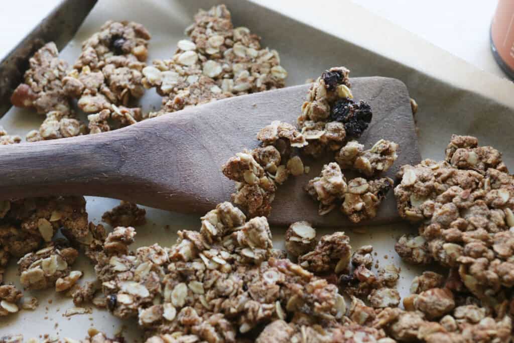 Healthy and Crunchy Protein-Packed Granola on a pan with a wooden spatula