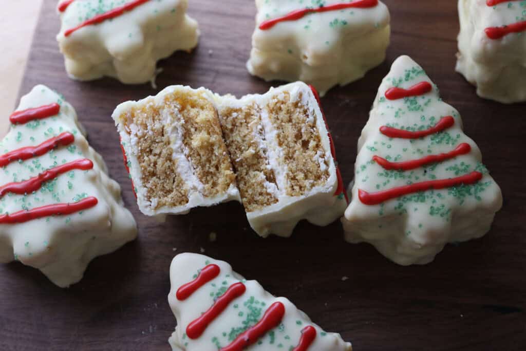 Fresh Milled Little Debbie Christmas Tree Cakes on a wooden board with one cut in half