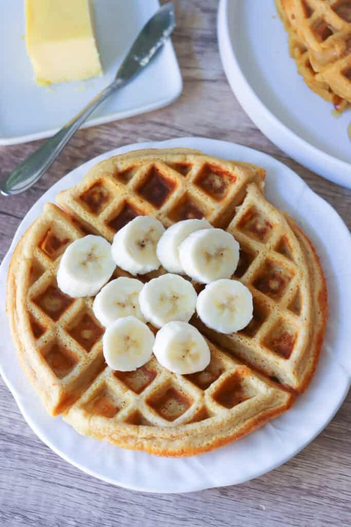 a Freshly Milled Healthy High Protein Waffle topped with a sliced banana on top