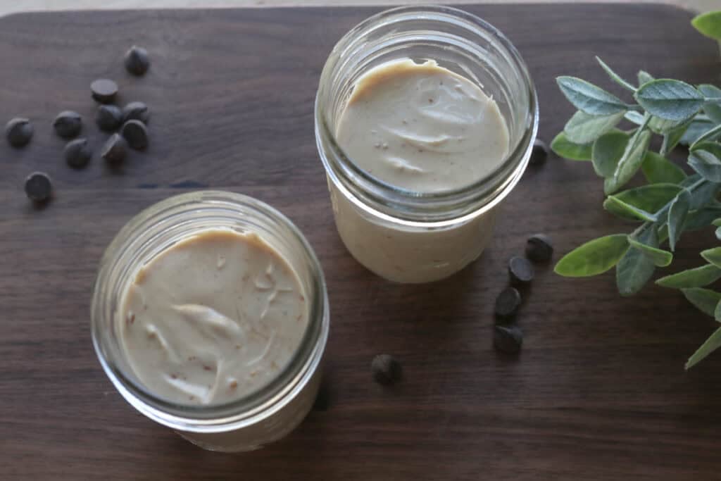 High Protein Chocolate Peanut Butter Yogurt in glass jars on a wooden board