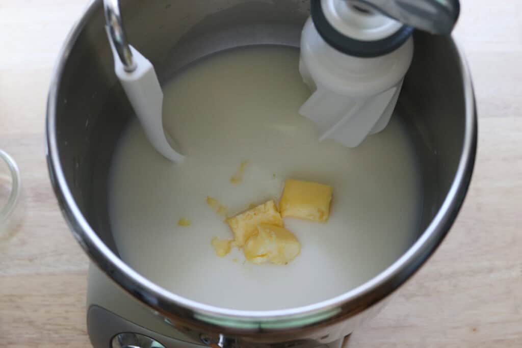 milk and butter in a mixing bowl to make freshly milled english muffins