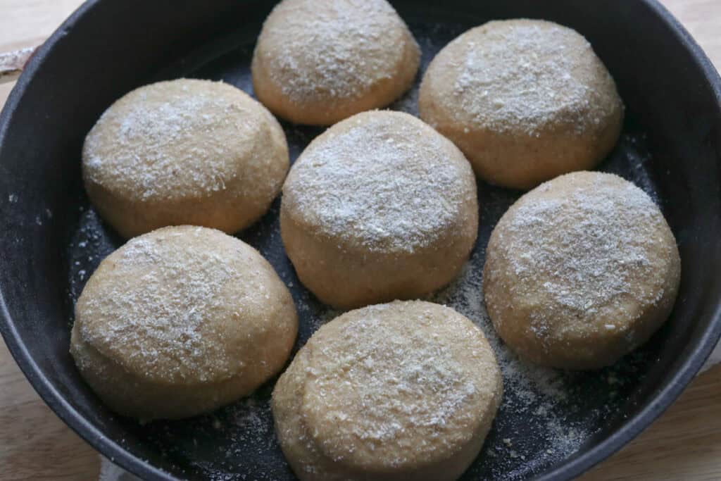freshly milled english muffins in a cast iron pan