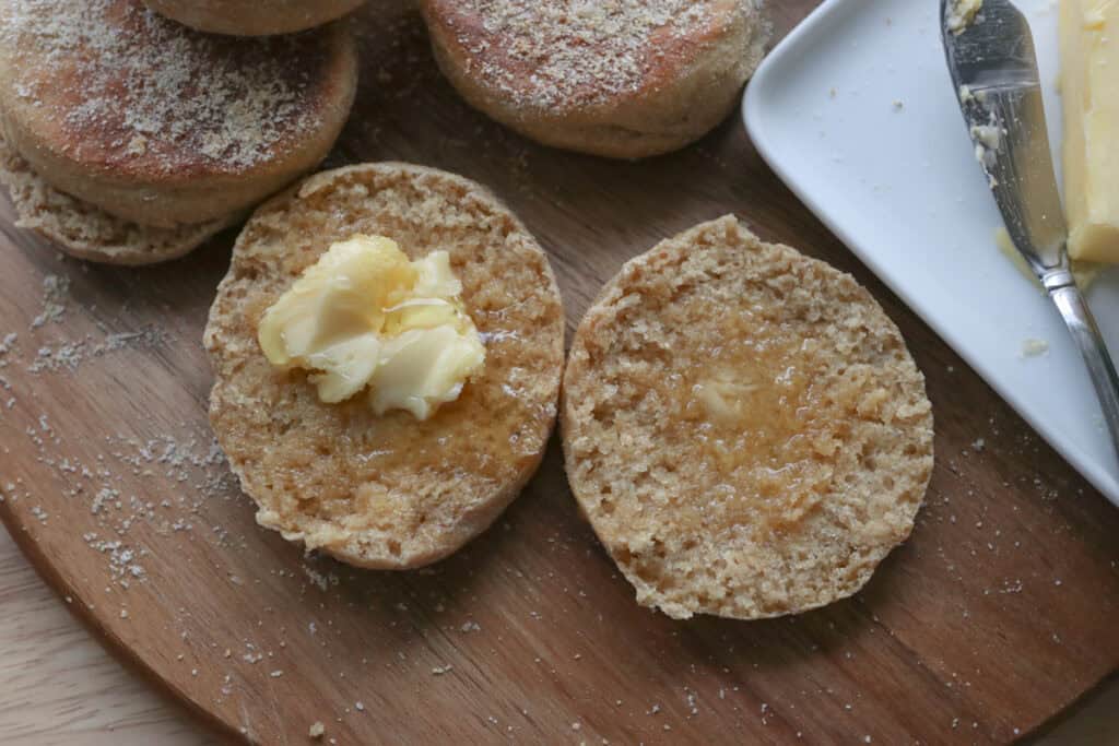 a freshly milled english muffin with butter and honey on it