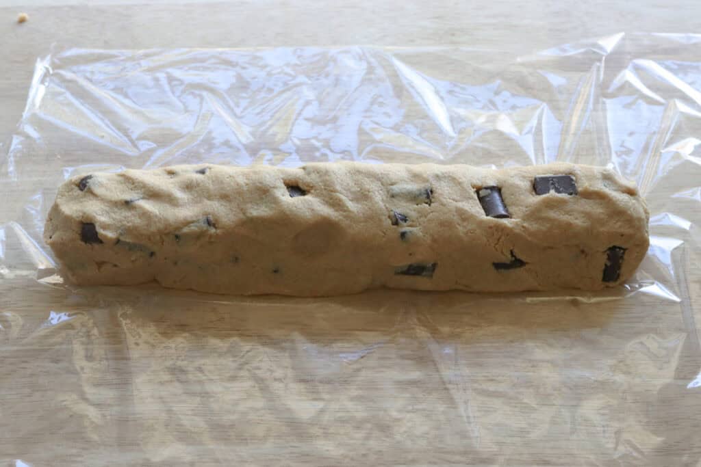 Freshly Milled Slice and Bake Chocolate Chunk Cookie dough log on a piece of plastic wrap