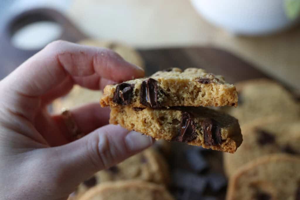 someone holding a Freshly Milled Slice and Bake Chocolate Chunk Cookie that has been broken in half