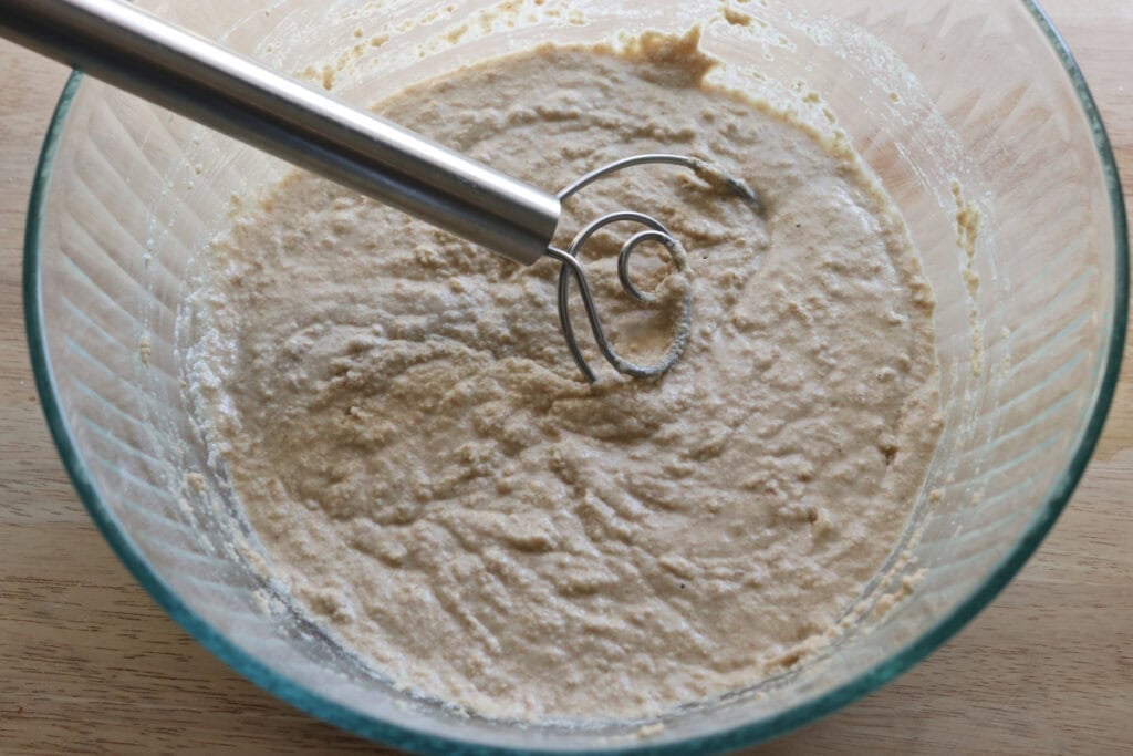 dough that has been mixed together and bubbly in a glass bowl