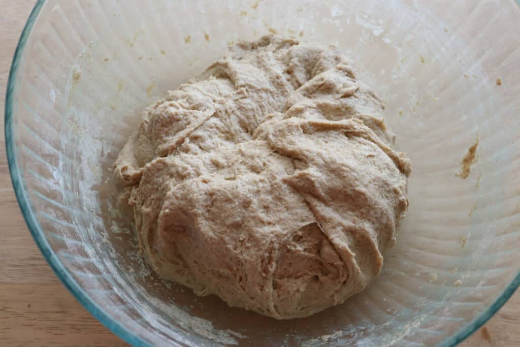 fresh milled dough in a glass bowl that is rising