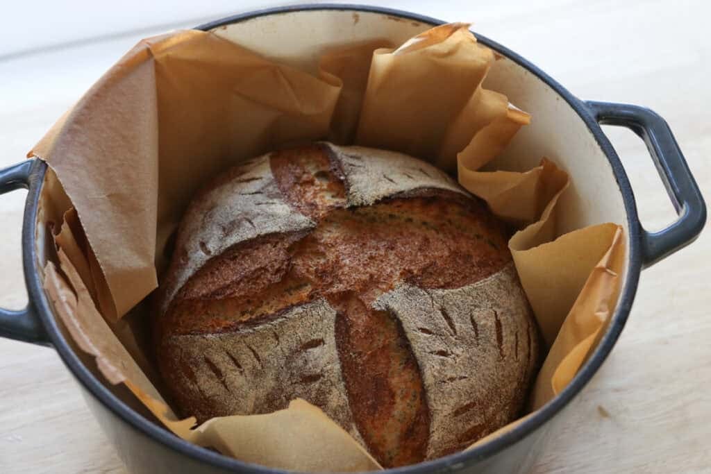 fresh milled artisan loaf in a cast iron pot with parchment paper