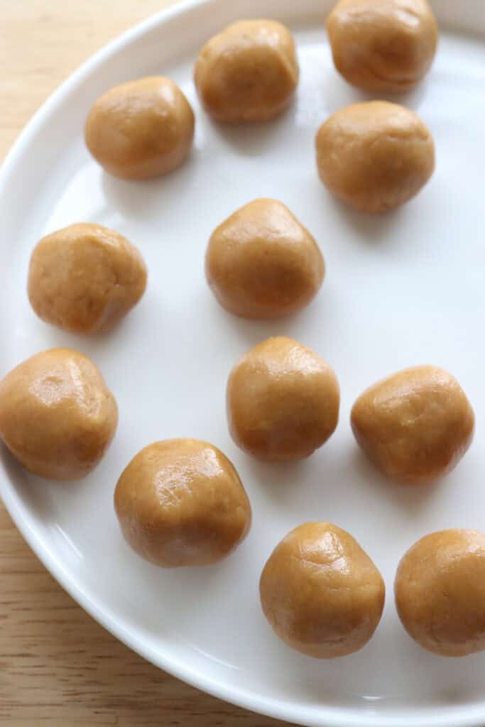 peanut butter balls on a white plate to go on the fresh milled buckeye brownie cookies