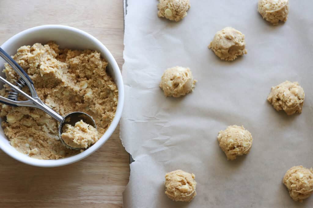 Freshly Milled White Chocolate Macadamia Cookie dough scooped onto a baking sheet