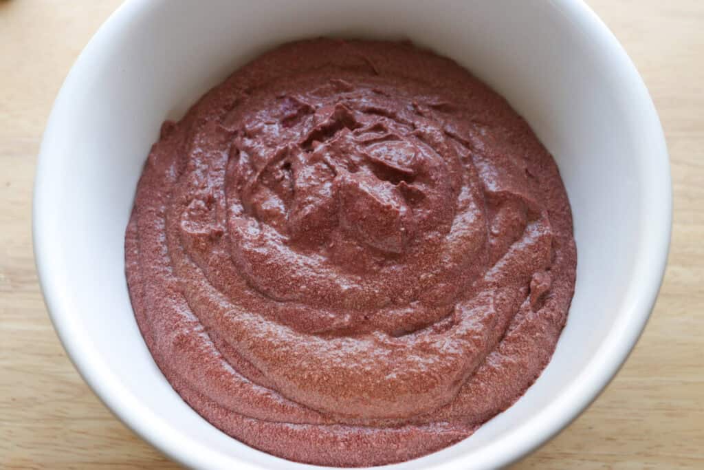 freshly milled red velvet cupcake batter in a white bowl 