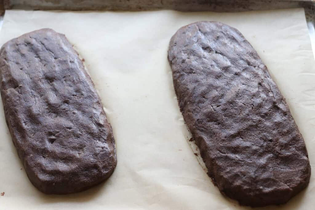 two loaves of fresh milled double chocolate biscotti on a baking sheet