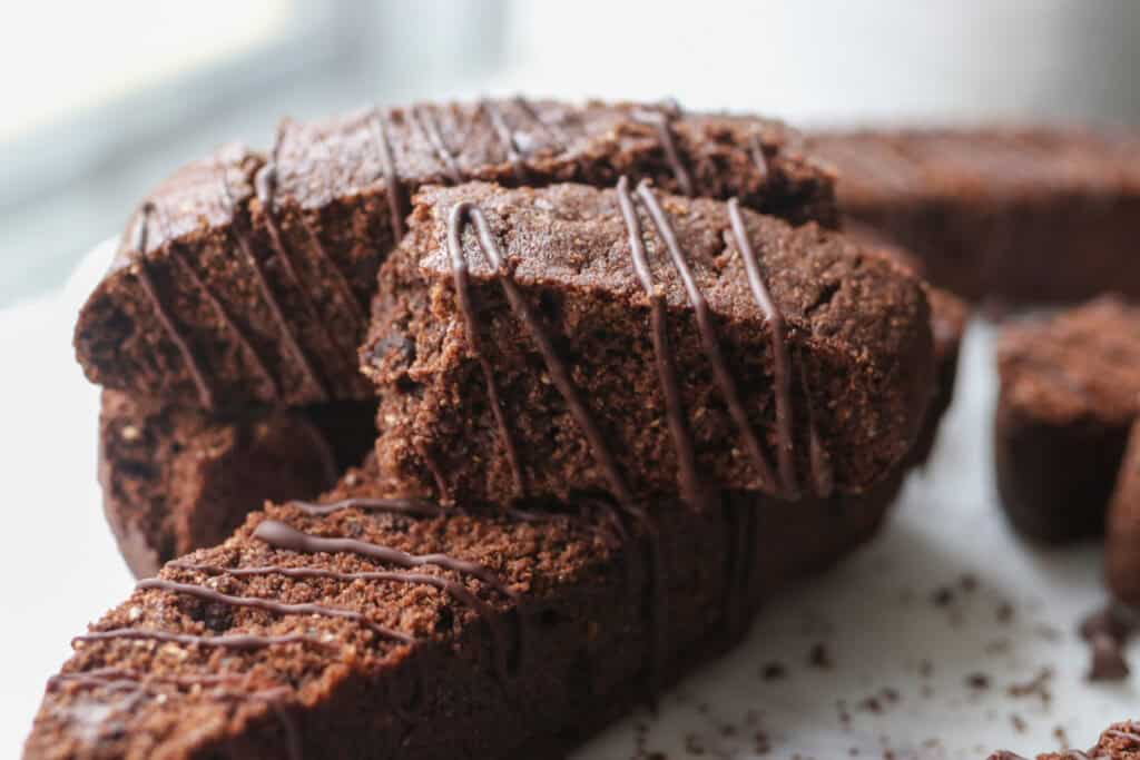fresh milled double chocolate biscotti with chocolate drizzle on it stacked together