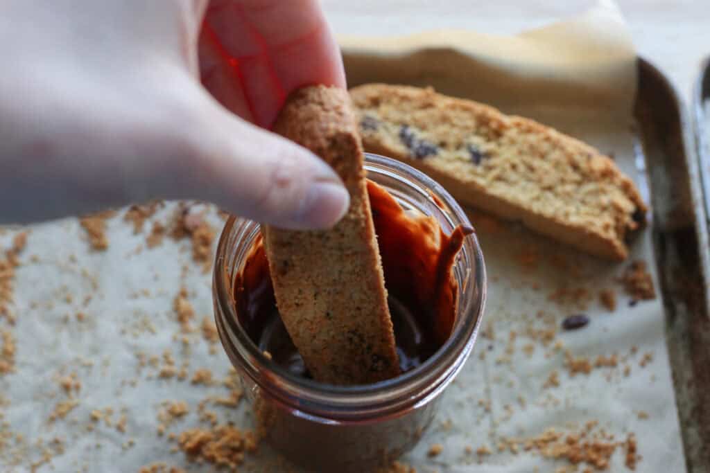 dipping freshly milled chocolate chip biscotti into melted chocolate