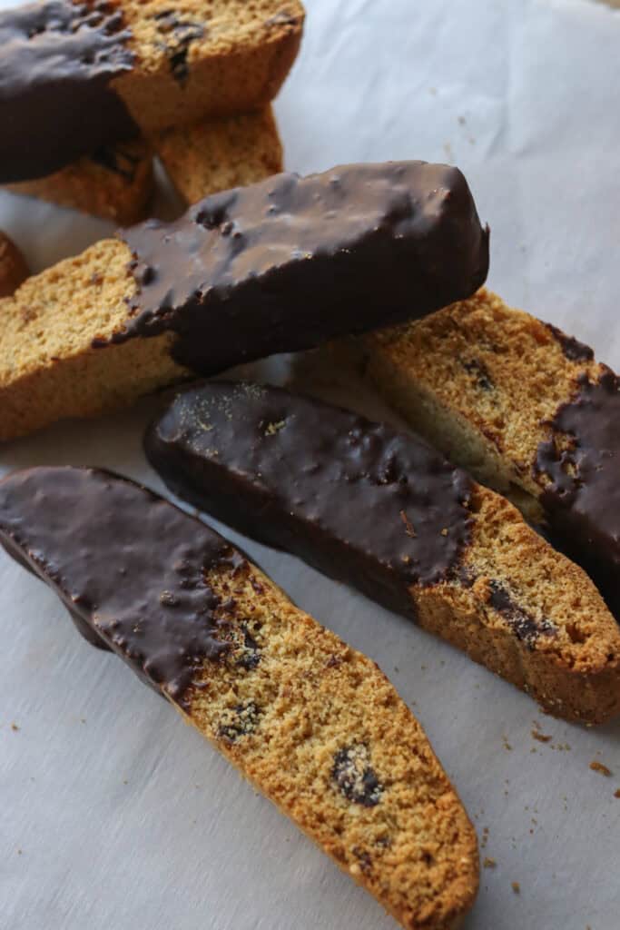 freshly milled chocolate chip biscotti on white parchment covered in chocolate