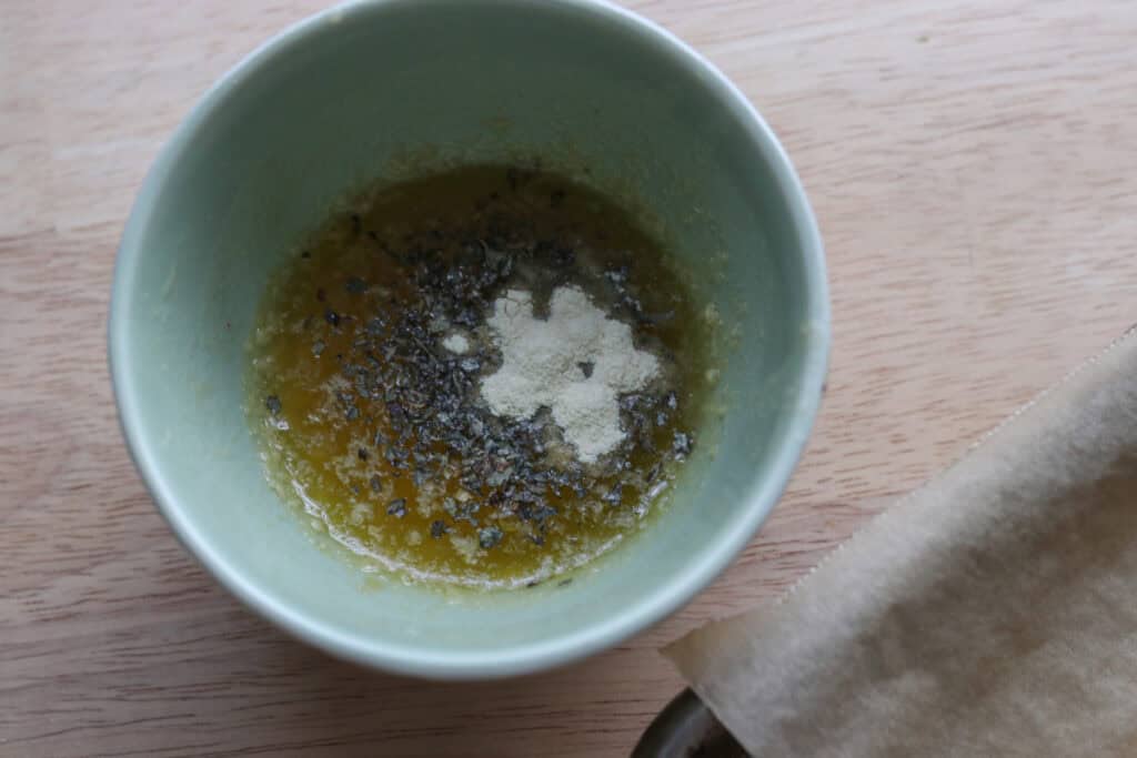 garlic powder, butter, and herbs in a bowl to make garlic butter for the fresh milled sourdough breadsticks 