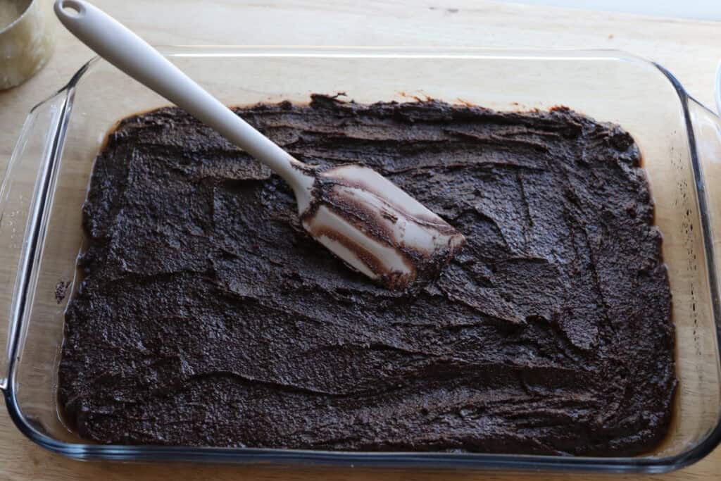 freshly milled fudgy cosmic brownie batter spread out in a baking dish