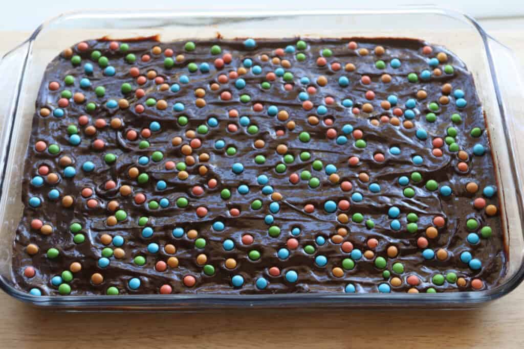 freshly milled fudgy cosmic brownies topped with candied chocolate chips in a pan