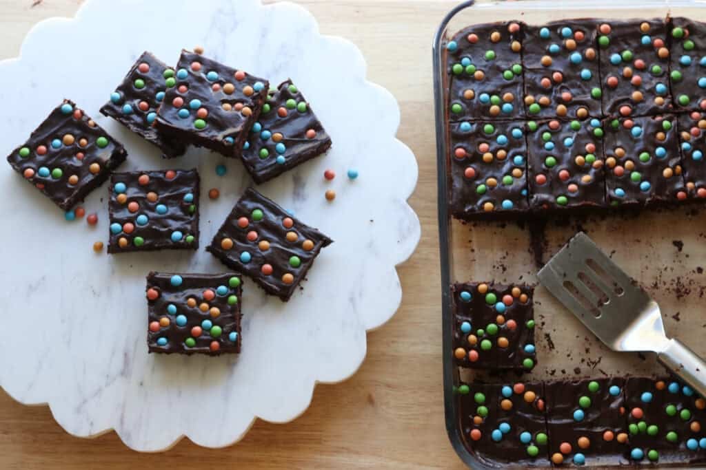 freshly milled fudgy cosmic brownies on a platter with more in a baking dish