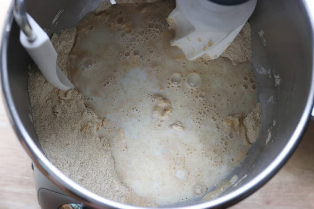 honey and milk added to a mixing bowl to make fresh milled flaky buttery croissants