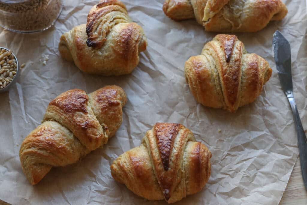 fresh milled flaky buttery croissants with a golden crust and a butter knife