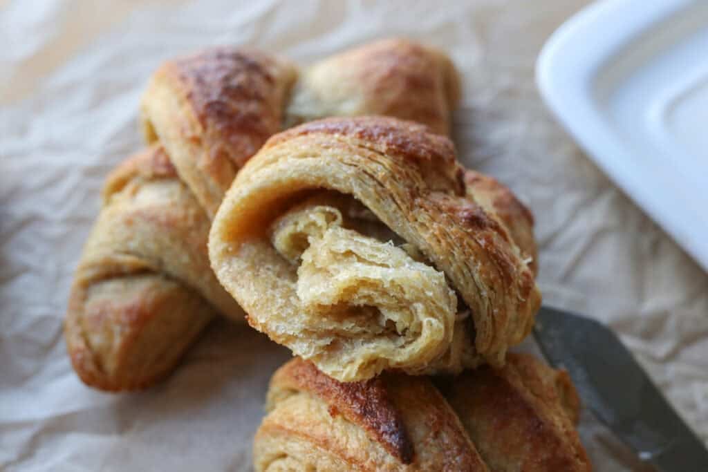 a fresh milled flaky buttery croissant that has been torn in half