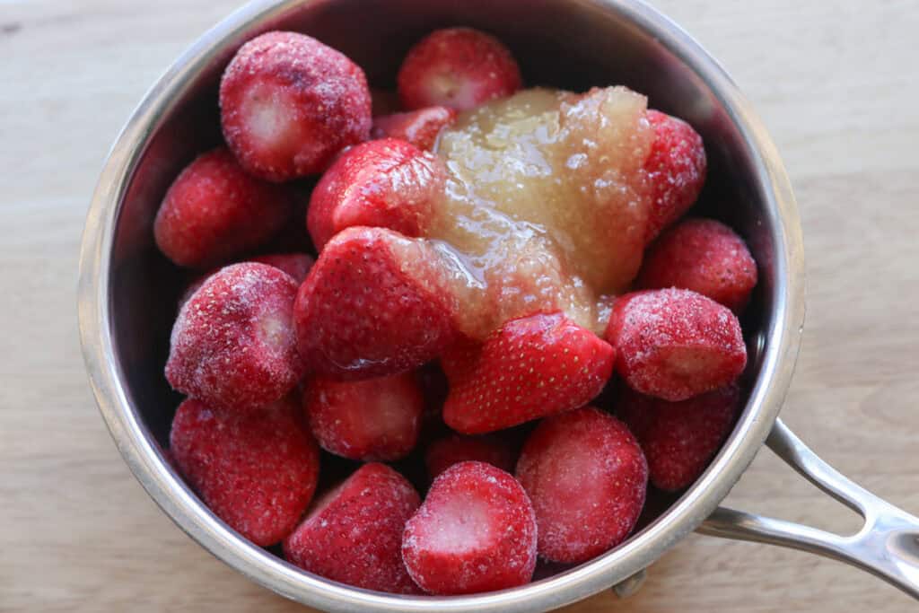 strawberries, honey, and lemon juice in a pot to make the filling for Freshly Milled Valentine's Strawberry Cinnamon Rolls