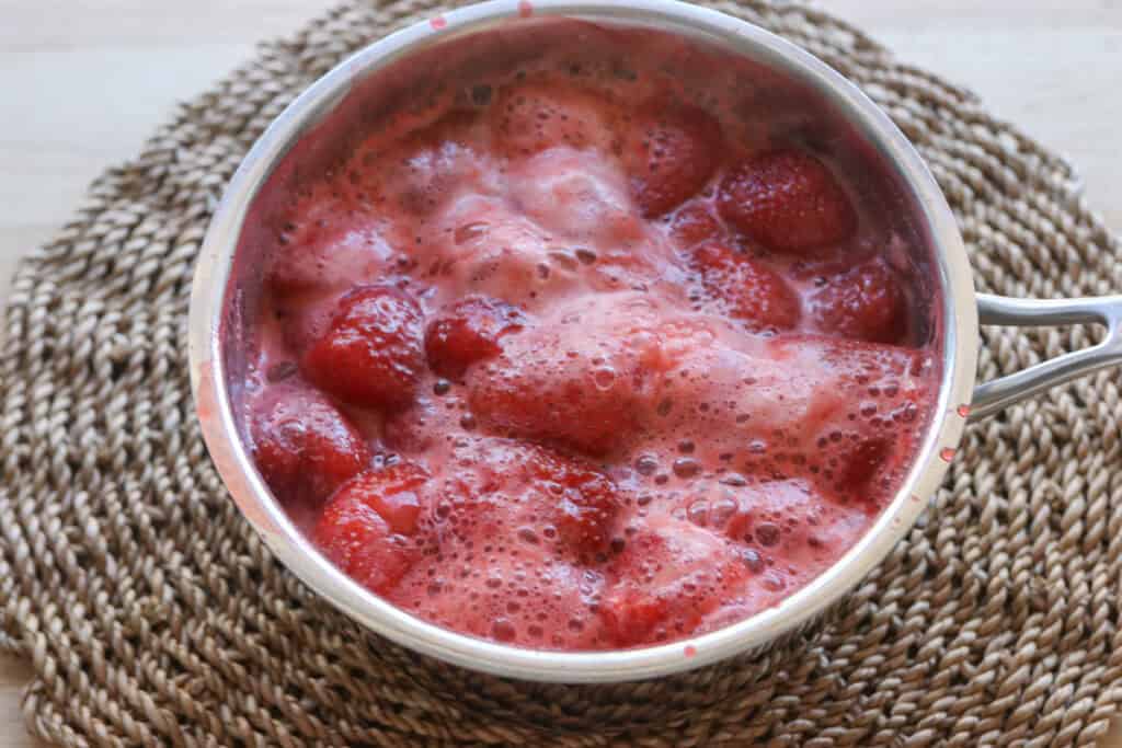 simmering strawberries in a saucepan for Freshly Milled Valentine's Strawberry Cinnamon Rolls