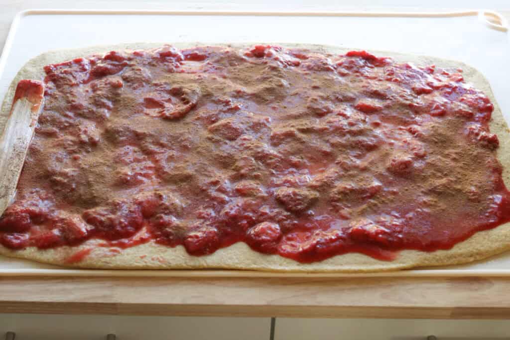 strawberries and cinnamon spread over top of the dough for Freshly Milled Valentine's Strawberry Cinnamon Rolls