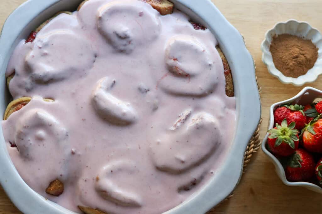 Freshly Milled Valentine's Strawberry Cinnamon Rolls covered in pink strawberry frosting