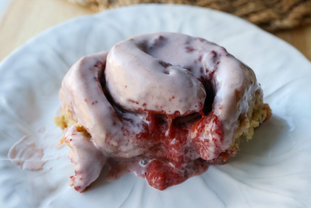 a Freshly Milled Valentine's Strawberry Cinnamon Roll on a white plate