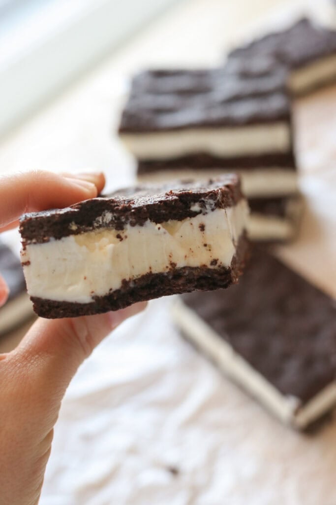 someone holding a fresh milled Ice Cream Sandwich with a bite taken out of it