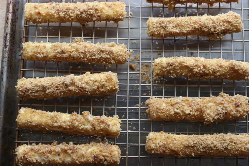 fresh milled fried mozzarella sticks on a wire rack