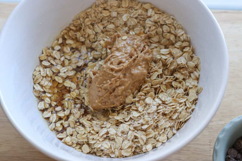 cashew butter added to a white bowl to make Easy and Delicious Copycat Heavenly Hunk Squares