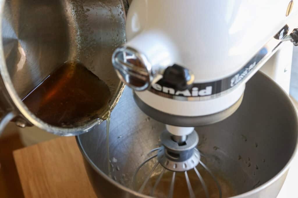 adding honey to the mixing bowl to make homemade marshmallow fluff