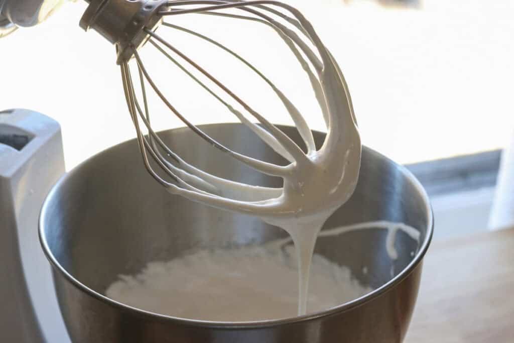 Homemade marshmallow fluff that has been whipped in a mixing bowl with a whisk attachment